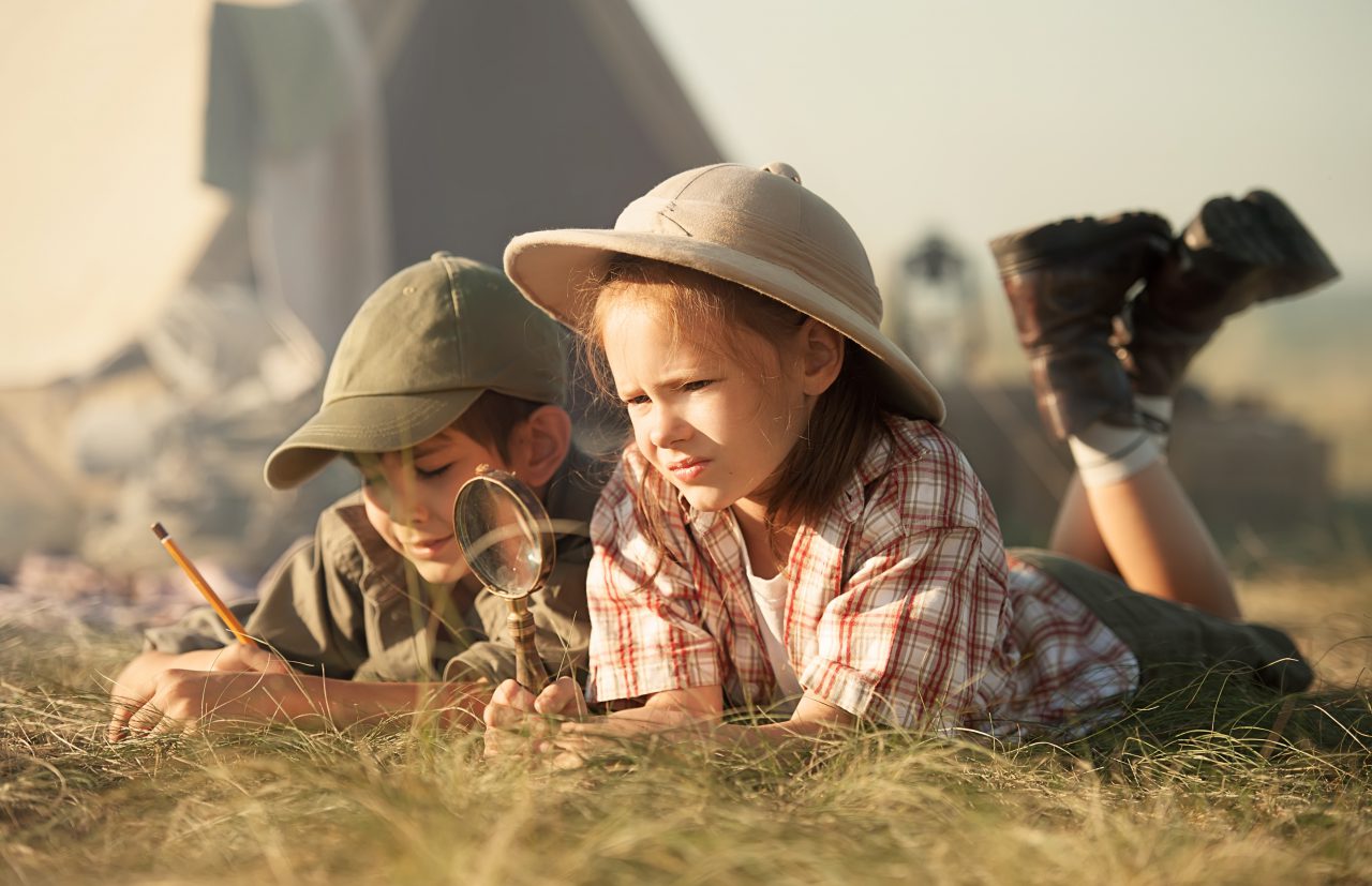 Two children explore insects and plants on earth