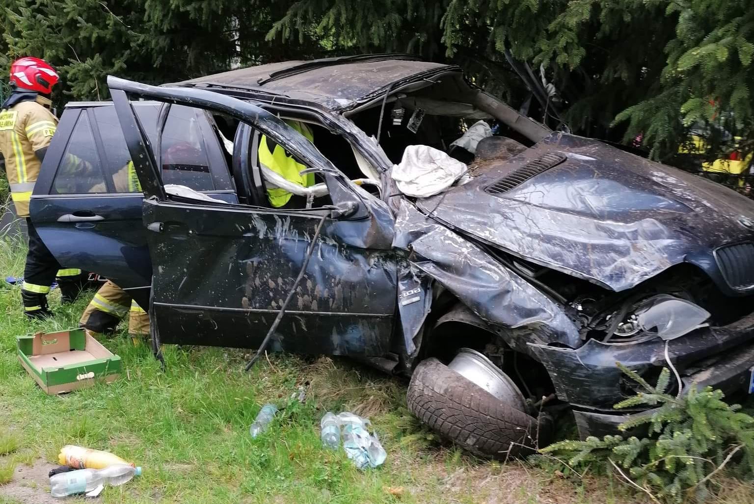 Pędzące szutrową drogą BMW uderzyło w drzewo i dachowało. Dwie osoby zostały ranne (zdjęcia)