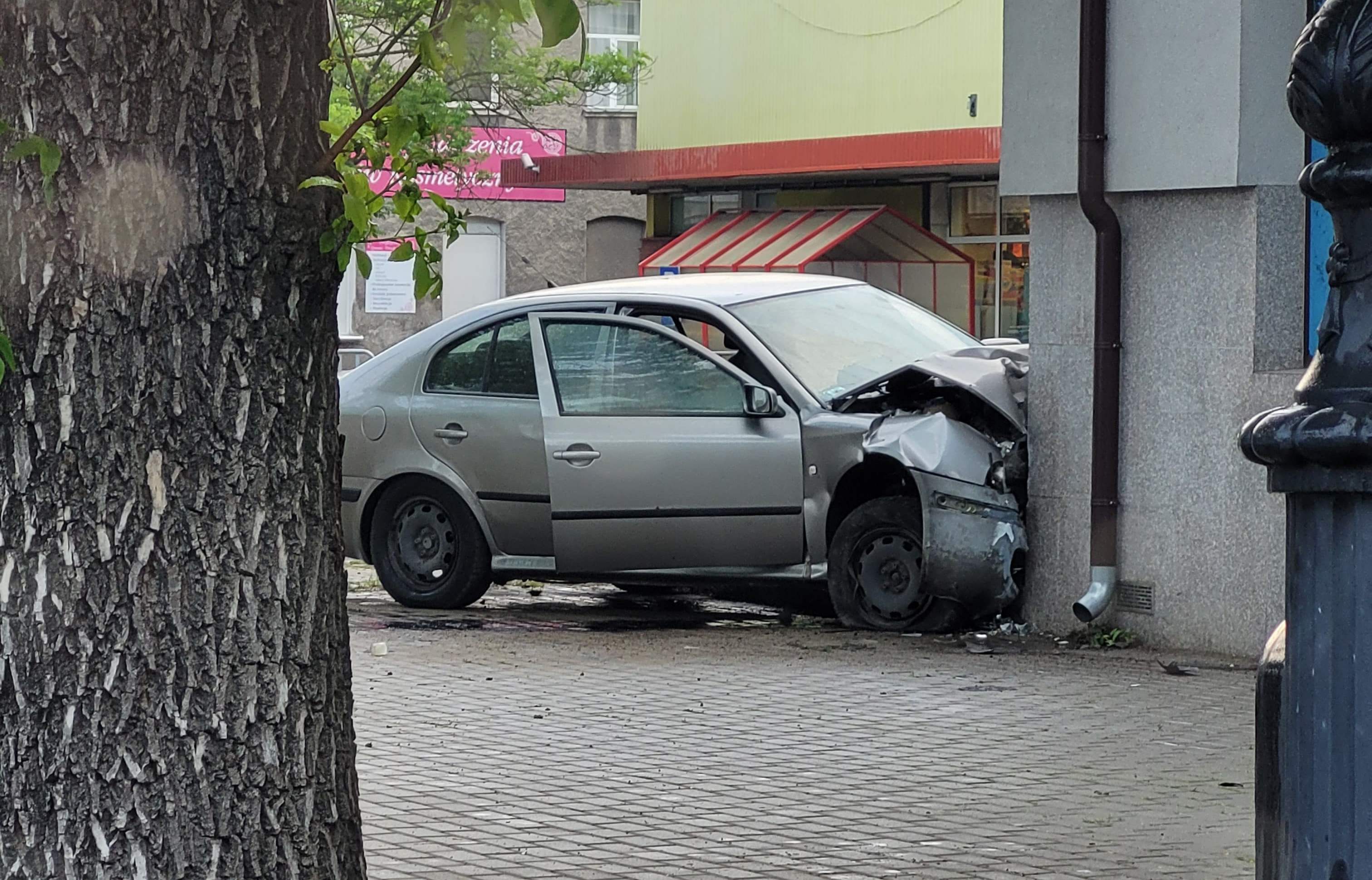 Na zakręcie pojechał skodą prosto i uderzył w budynek. Kierujący pijany, poszukiwany i bez uprawnień (zdjęcia)