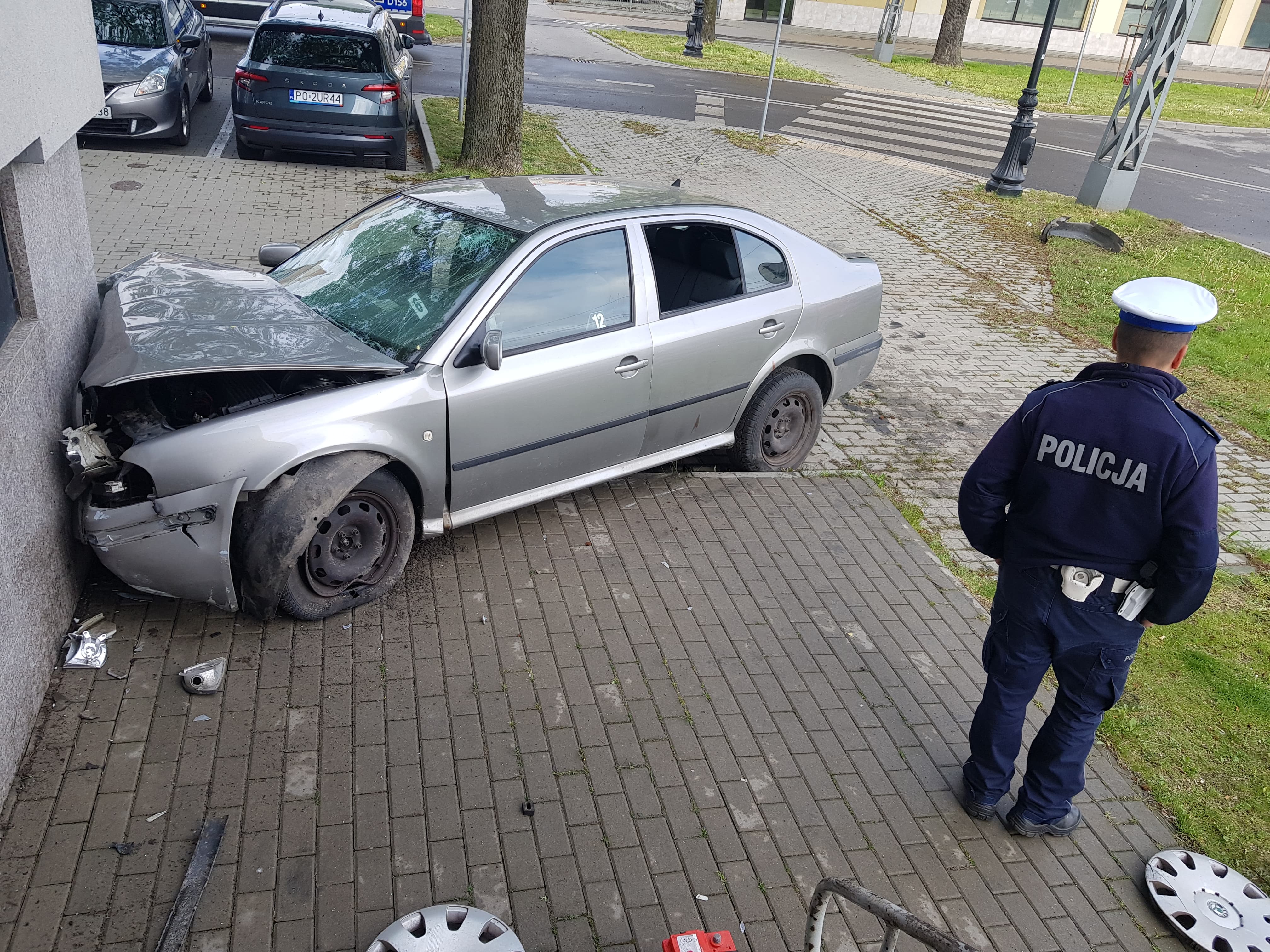 Na zakręcie pojechał skodą prosto i uderzył w budynek. Kierujący pijany, poszukiwany i bez uprawnień (zdjęcia)