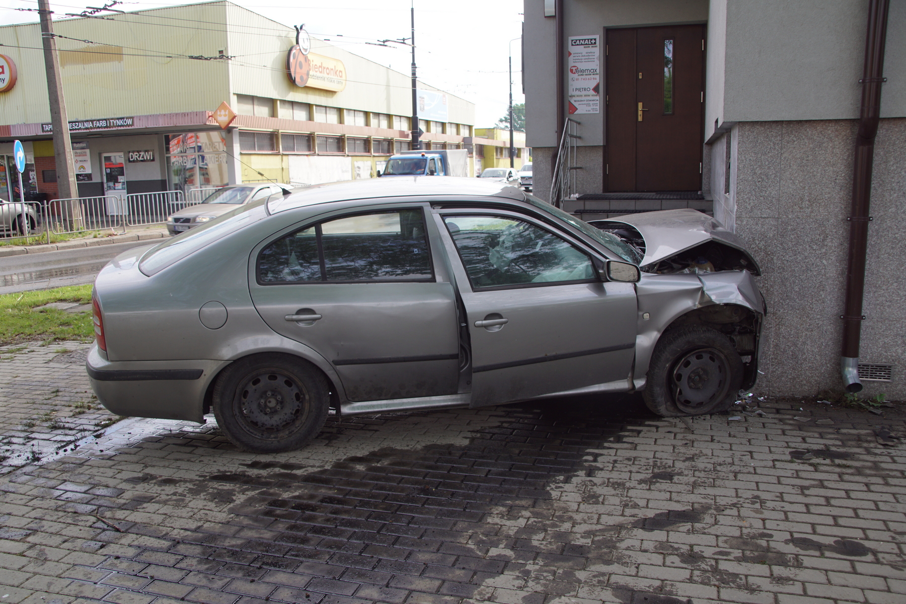 Na zakręcie pojechał skodą prosto i uderzył w budynek. Kierujący pijany, poszukiwany i bez uprawnień (zdjęcia)