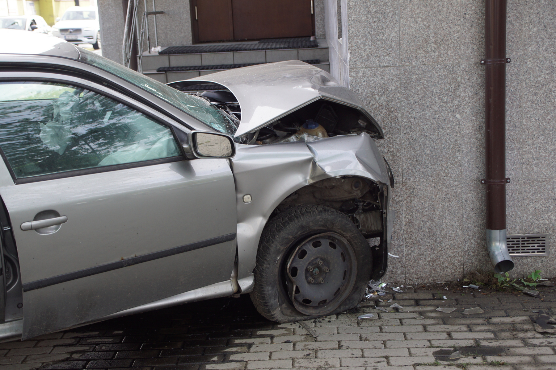 Na zakręcie pojechał skodą prosto i uderzył w budynek. Kierujący pijany, poszukiwany i bez uprawnień (zdjęcia)