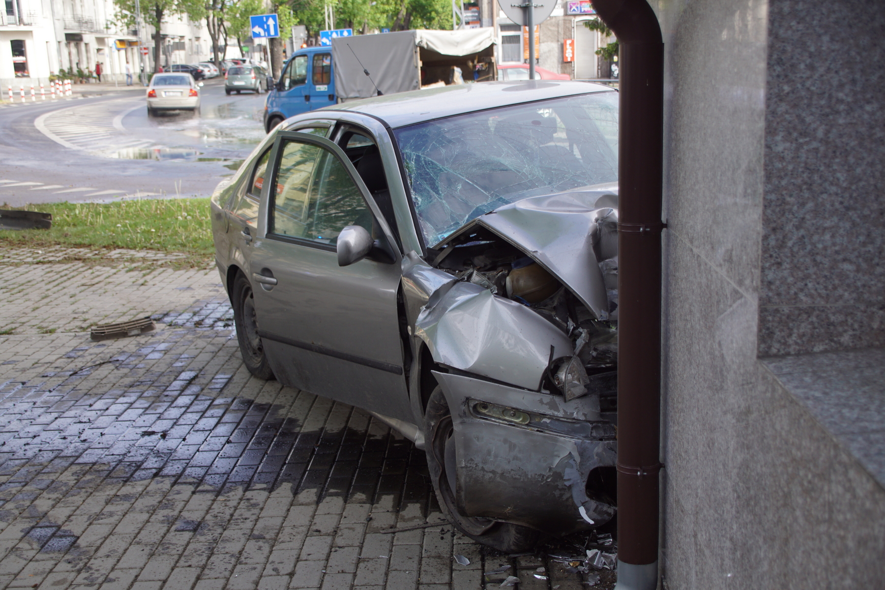 Na zakręcie pojechał skodą prosto i uderzył w budynek. Kierujący pijany, poszukiwany i bez uprawnień (zdjęcia)