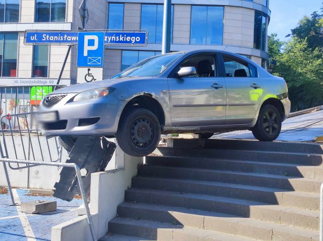 Na łuku jezdni pojechał prosto, mazda uderzyła w barierki i zawisła nad schodami (zdjęcia)