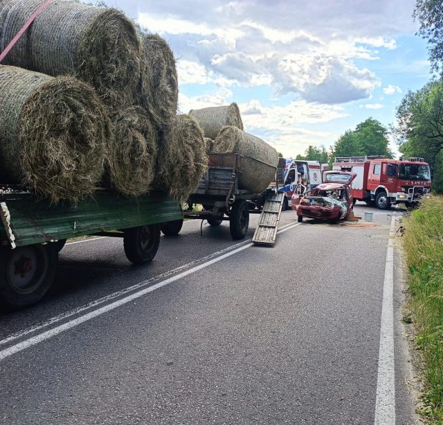 Fiat wbił się w przyczepę załadowaną sianem. Trwa akcja ratunkowa, droga jest zablokowana (foto)
